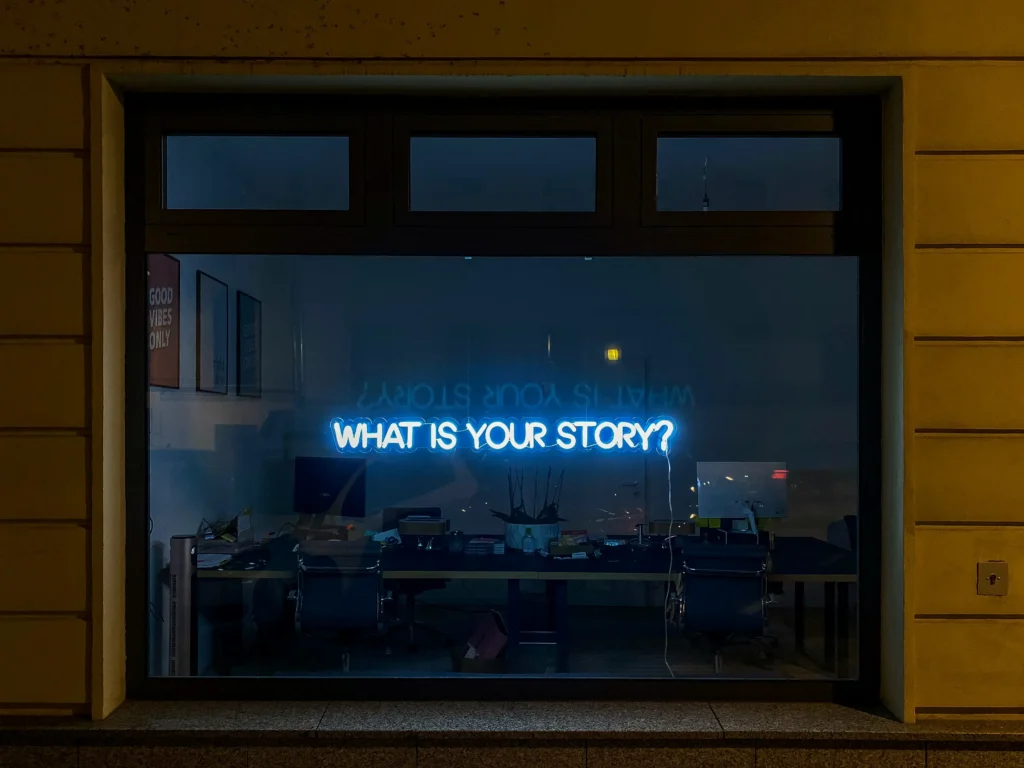 Butiksfönster med blå neonskylt där det står: what is your story?