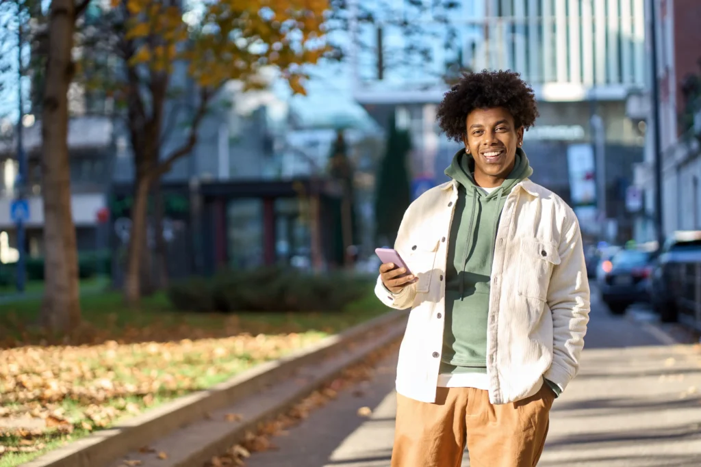 Smiling young african american teenager using phone